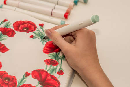 Hand drawing a red poppy wreath sketch in a sketchbook with alcohol based sketch drawing markers. Remembrance Day and Anzac day.の写真素材