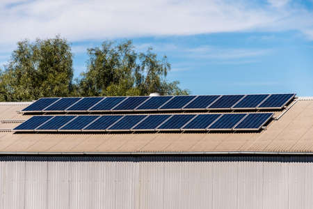 Solar panels on the roof of industrial building warehouse. Renewable solar energy conceptの写真素材