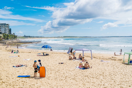Sydney, Australia - 2022-01-14. People on a sandy beach near the ocean. Vacation travel summer recreation. Storm cloud in the sky. Cronulla Beach, NSW, Australia.のeditorial素材