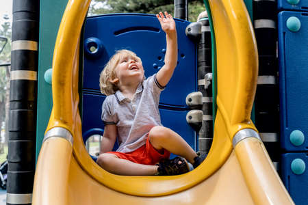 Happy toddler boy playing on a playground. Summertime childhood preschool child kid childcare kindergartenの写真素材