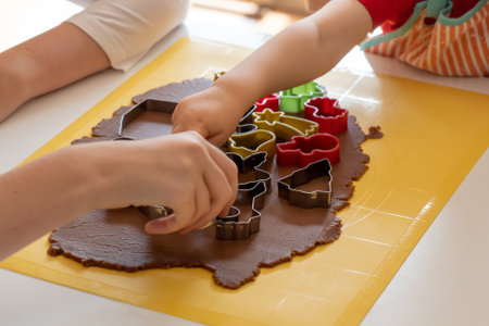 Selective focus. Kids making gingerbread cookies with various Christmas cookie cutters. Gingerbread dough. Family Christmas momentsの写真素材