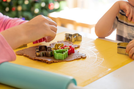 selective focus. Kids making gingerbread cookies with various Christmas cookie cutters. Gingerbread dough. Family Christmas fun momentsの写真素材