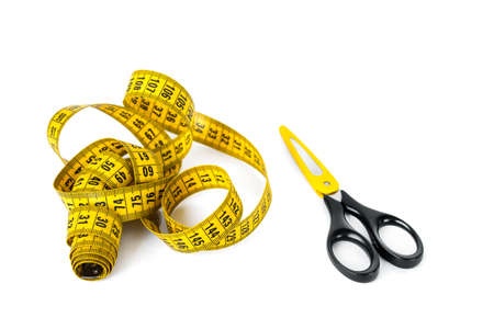 Sewing accessories - measuring tape and scissors with yellow color accent isolated on white.の写真素材