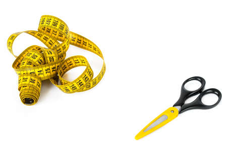 Sewing accessories - measuring tape and scissors with yellow color accent isolated on white with blank space.の写真素材