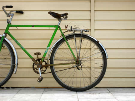 Old bicycle with green frame and rusted metallic parts.の写真素材