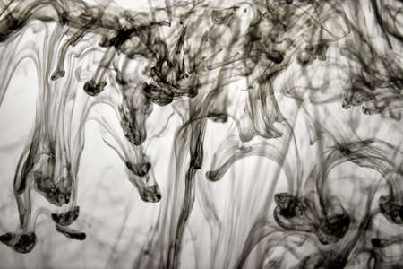 Pattern made with swirls of black ink in water on white background.の写真素材