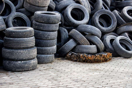 Waste of used car tires in the tire repair shop yard with a copy space. 