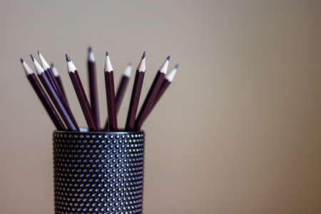 Many graphite pencils standing in black glass container. Drawing utensils.の写真素材