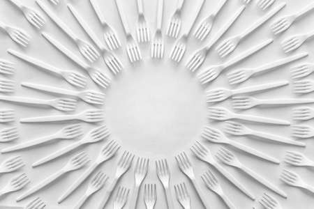 Circular pattern of white forks on. Black and white photo of kitchen utensils with copy space for text in the center. Paper effect.の写真素材