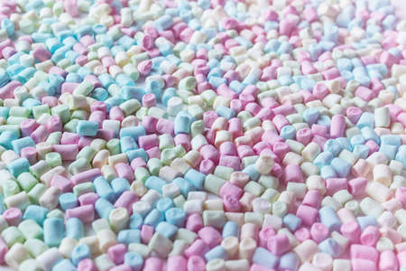 Background with small multi colored marshmallows. Tinged with pink color background with blue, green, pink marshmallows.の写真素材