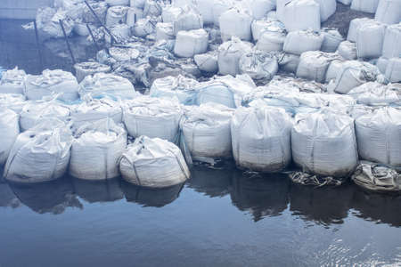 Filled white sand bags for control of water flow.の写真素材