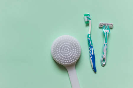 Hygiene utensils - massage washing brush, razor, tothbrush - on minty green background. Photo with empty copy blank space.の写真素材