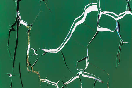Surface covered with green plastic stiky film with large wide cracks.の写真素材
