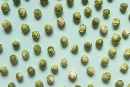 Pattern made of brussel cabbages arranged on minty green background. Healthy food - vegetables.