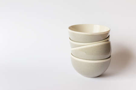Kitchenware - minimalistic cooking bowls. Four 4 bowls stacked on each other on white background. Photo with copy blank space on the right.の写真素材