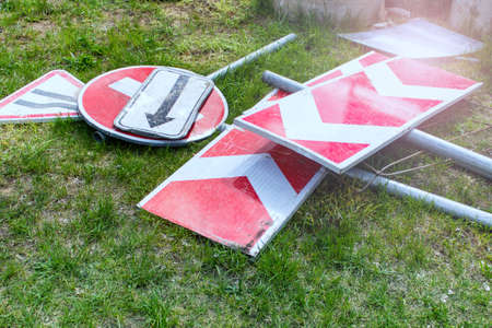 Damaged old unused road signs laying on the grass.の写真素材
