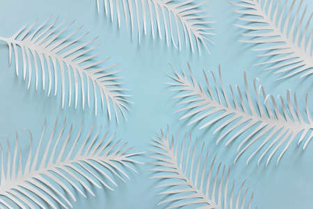 Romantic dreamy background with many handmade paper cut spiky feathers on bright blue background.