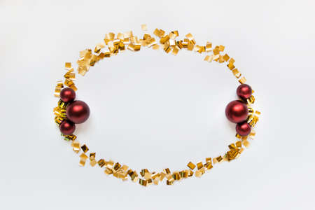 Golden simmetric wreath with three red balls on white backgound.