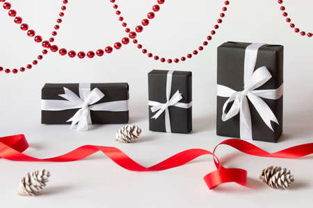Winter Christmas holidays background greeting card with three presents, curvy red satin ribbon,...