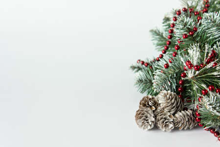 Simple Christmas holiday background with copy blank space and evergreen tree with pine cones and red ball garland.の写真素材