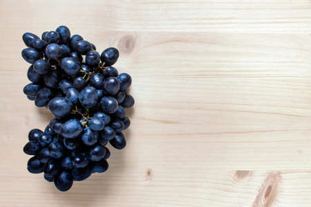 Blue wine grape berries resveratrol polyphenol antioxidant source on wooden background.の写真素材