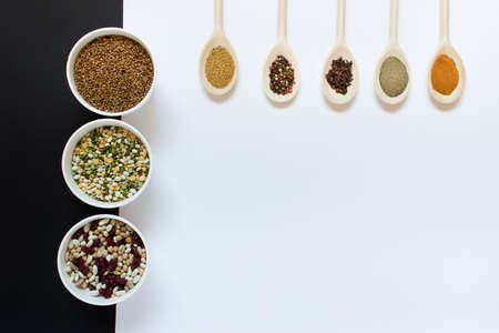 Collection of cooking ingredients variety of grains and legumes with spicing herbs in wooden spoons...