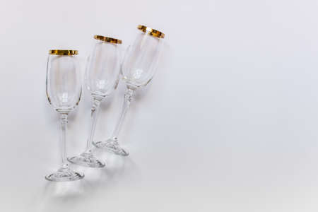 Clear empty wine glasses on white background with golden outline. Photo with copy blank space.の写真素材