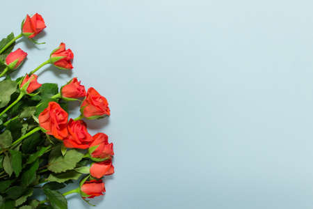 Valentine day greeting card with bouquet of roses on blue background. Photo with copy blank space.