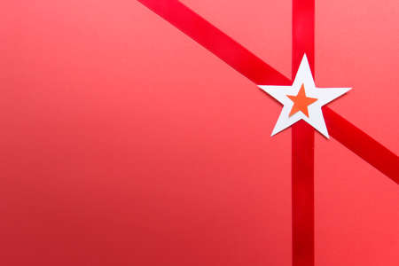 Abstract presentation greeting invitation card with paper stars, satin ribbon on red background.の写真素材