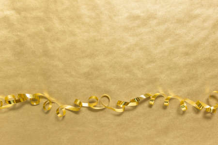 Golden festive backgound with wavy shiny ribbon and copy blank space.