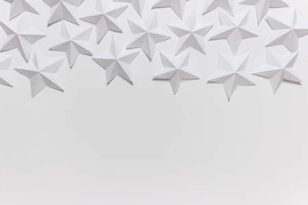 White folded origami stars on white background.Decorative background with copy blank space.の写真素材