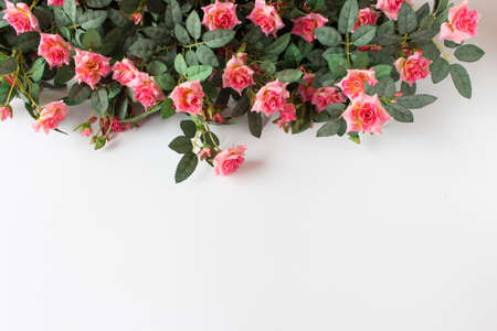 Background with pink artificial roses arranged on top of image. Photo with copy blank space.の写真素材