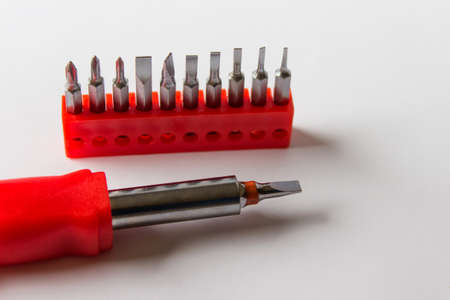 Set of metallic screwdrivers in red case on white background.
