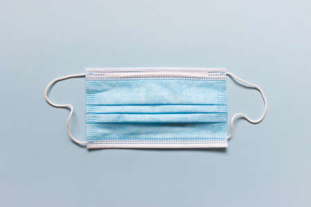 Medical blue folded face mask on blue background.