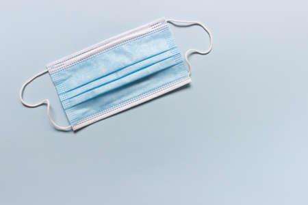 Medical blue folded face mask on blue background. Photo with copy blank space.の写真素材