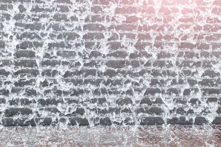 Pattern made by falling water in a city fountain waterfall with down stairs.の写真素材
