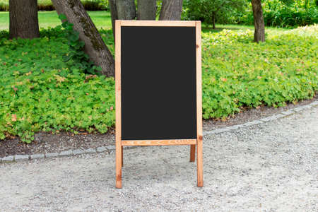 Mockup template of outside wooden chalk commercial board with blank black space.