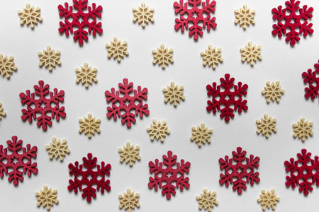 Christmas greeting card with wooden snowflakes red and yellow on white background.の写真素材