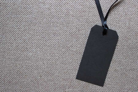 Blank black paper label on textured striped fabric. Photo with copy blank space.の写真素材