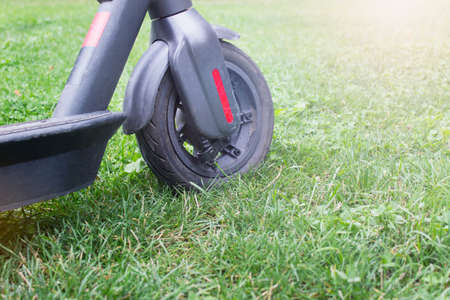 Electric city scooter wheel standing on grass.