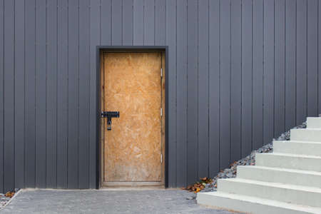 Door closed by padlock in wall and stairs.の写真素材