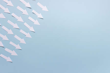 White arrows pointing to center on blue background. Photo with copy blank space.の写真素材