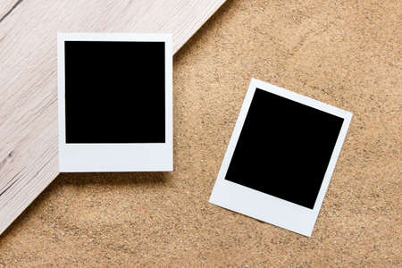 Two paper photos cards with blank copy space on wood and real sand background.