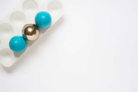 Simple minimalistic Easter greeting card with three blue and golden Easter eggs in plastic stand hold. Photo with copy blank space.の写真素材