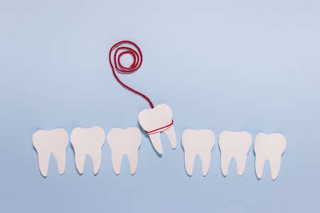 Oral health dentistry simple paper composition with tooth extraction idea on blue background.
