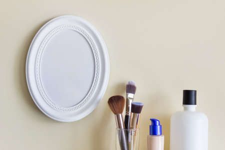 Composition with oval blank frame and makeup brushes with lotion makeup cream.の写真素材