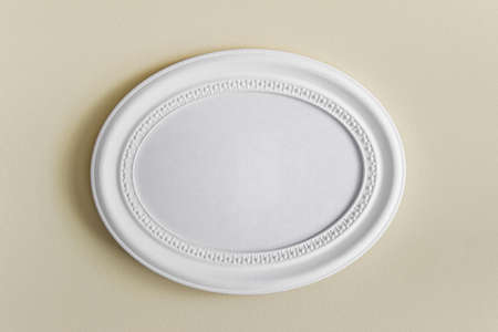 Mockup template with oval white textured photo frame with copy blank space hanging on yellow wall.の写真素材