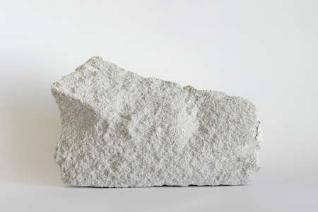 Large white building stone with visible porous surface on white background.の写真素材