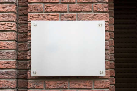 Mockup template with blank metallic board on street building facade.の写真素材