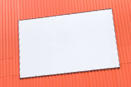 Large outside shop banner signboard on vibrant orange shop wall.の写真素材